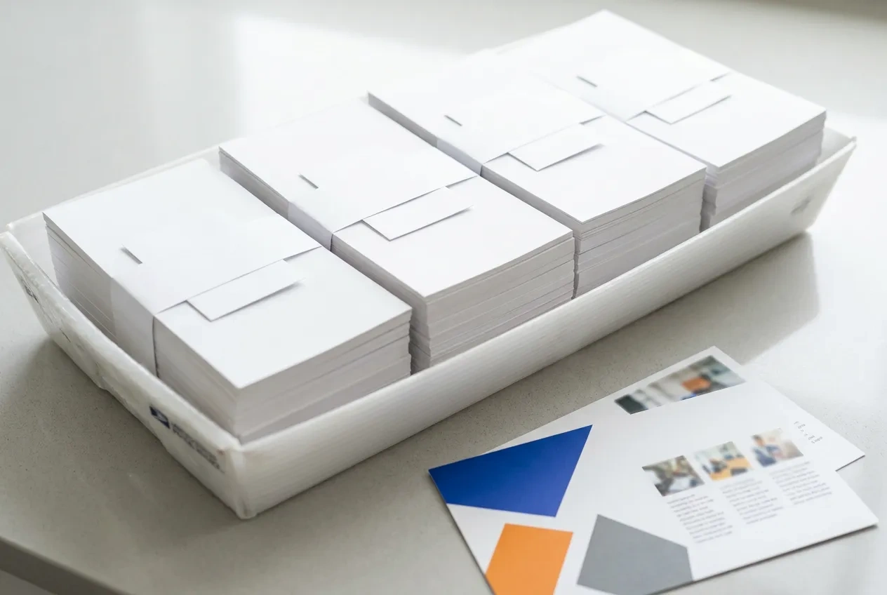 Bundles of oversized EDDM postcards banded with USPS facing slips, ready for the post office